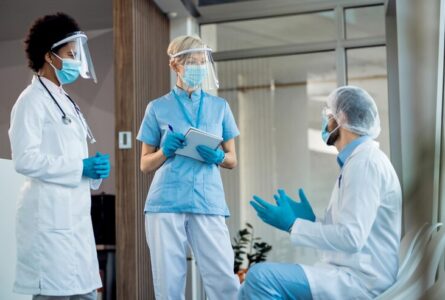 grupo-trabajadores-salud-hablando-pasillo-hospital-mientras-trabajan-pandemia-coronavirus_637285-11200